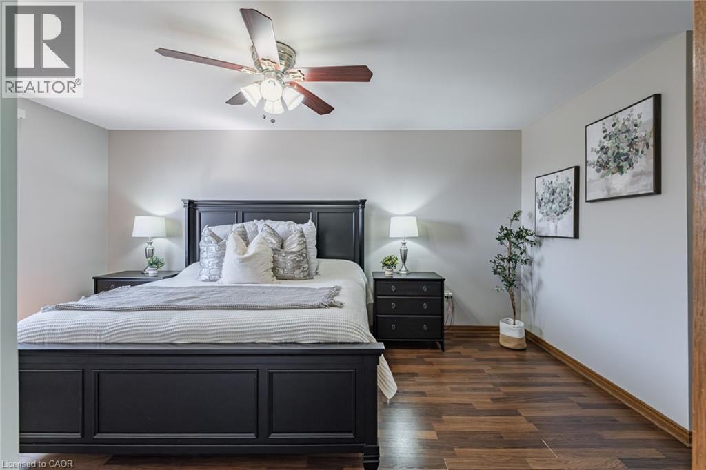 Spacious bedroom featuring wood-finish flooring, a ceiling fan with integrated lighting, and neutral wall tones - 141 Lynndale Road, Simcoe, ON