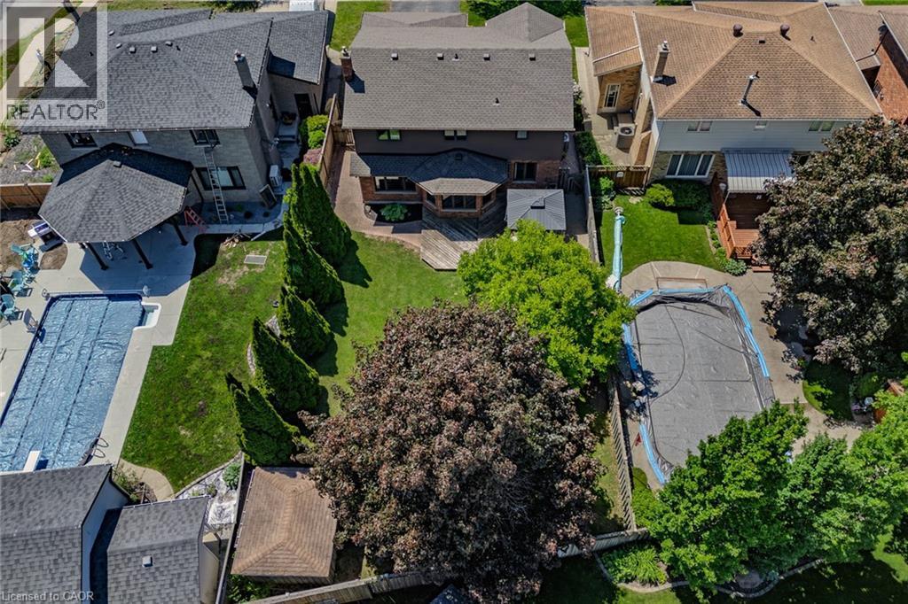 Expansive backyard featuring a covered swimming pool, mature perimeter trees, and a spacious lawn area - 141 Lynndale Road, Simcoe, ON