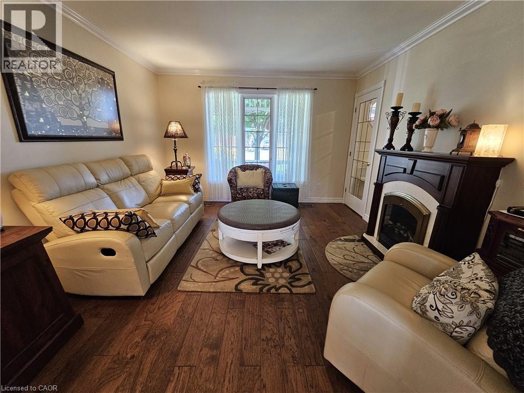 Living room features engineered hardwood and fireplace - 120 Lynndale Road, Simcoe, ON