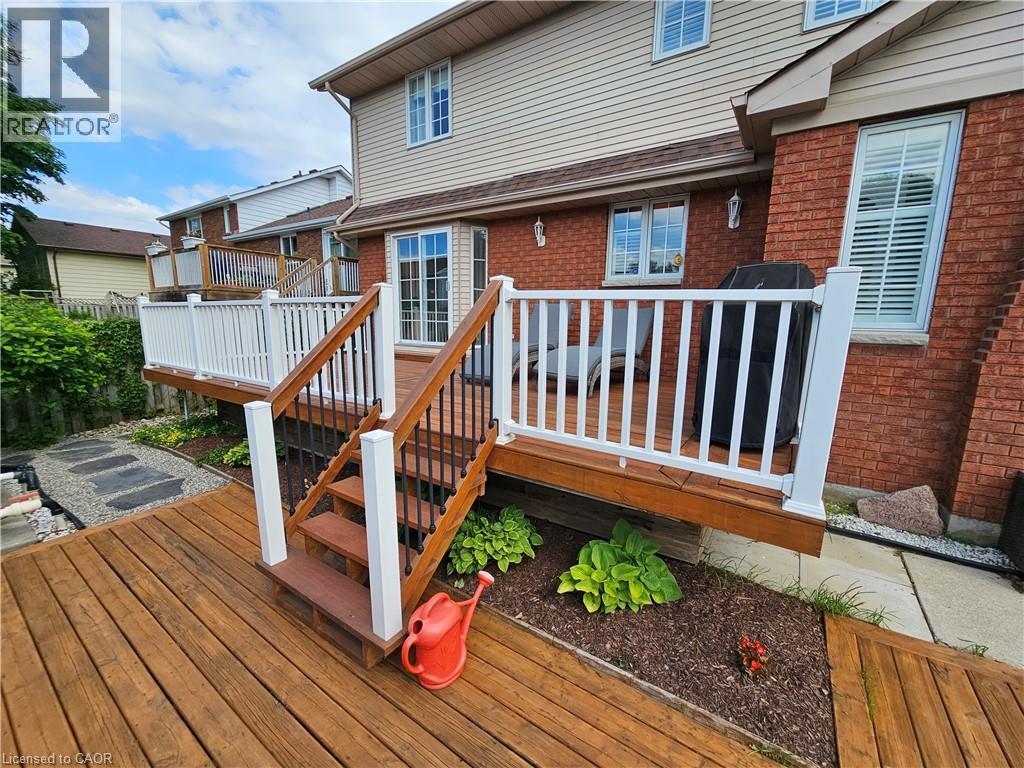 Multi-tier wood deck with white railings and black balusters - 120 Lynndale Road, Simcoe, ON