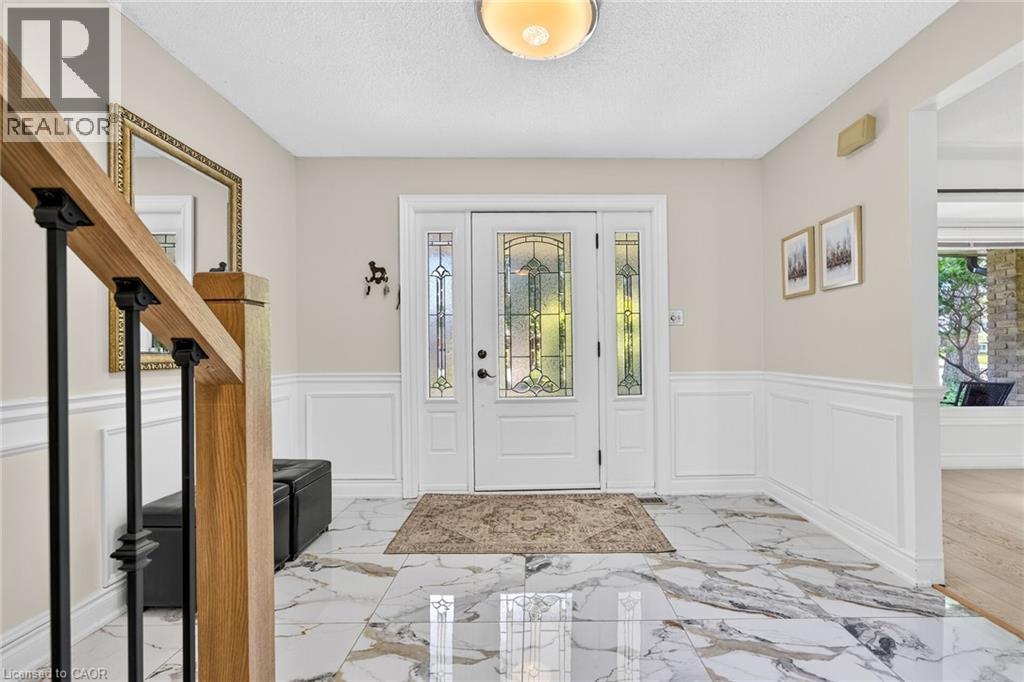 Entryway featuring white wainscoting and large format marble-look tile flooring - 15 Cheval Drive, Grimsby, ON - Indoor Photo Showing Other Room