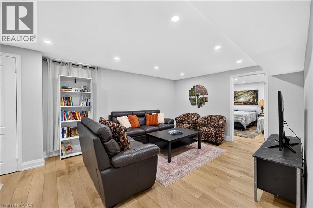 Spacious living area featuring light wood-finish flooring, recessed lighting, a built-in shelving unit, and a doorway opening to another room - 15 Cheval Drive, Grimsby, ON - Indoor
