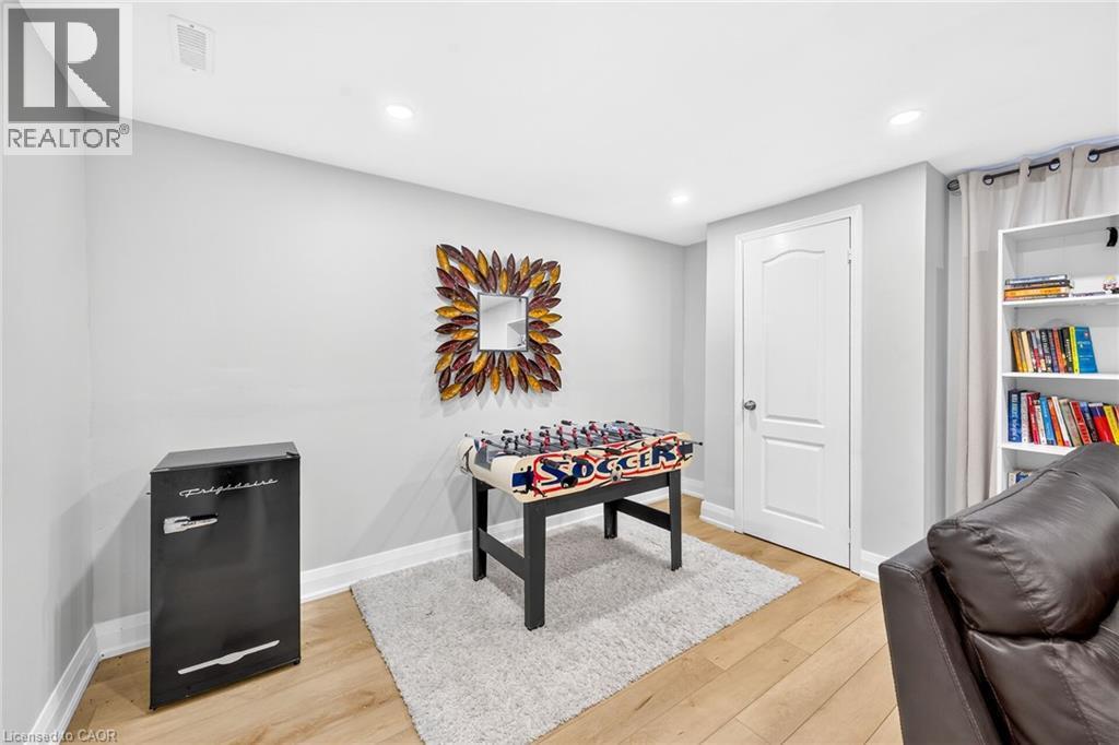 Finished room featuring light wood-finish flooring, recessed lighting, a built-in white bookshelf, and light gray wall paint - 15 Cheval Drive, Grimsby, ON - Indoor