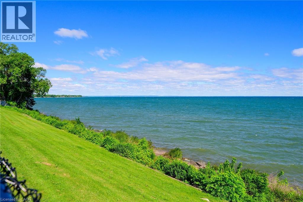 Expansive waterfront property featuring a gently sloping, manicured lawn and mature trees - 15 Cheval Drive, Grimsby, ON - Outdoor With Body Of Water With View