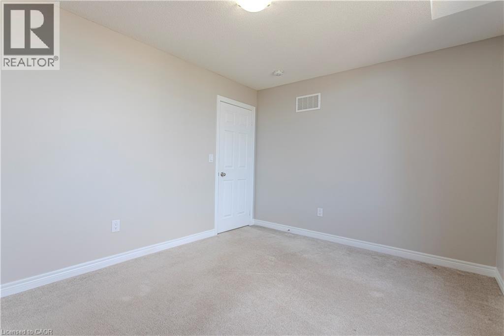 Neutral tone wall paint with white trim, light-colored carpet, and a white interior door - 3896 Tufgar Crescent, Burlington, ON