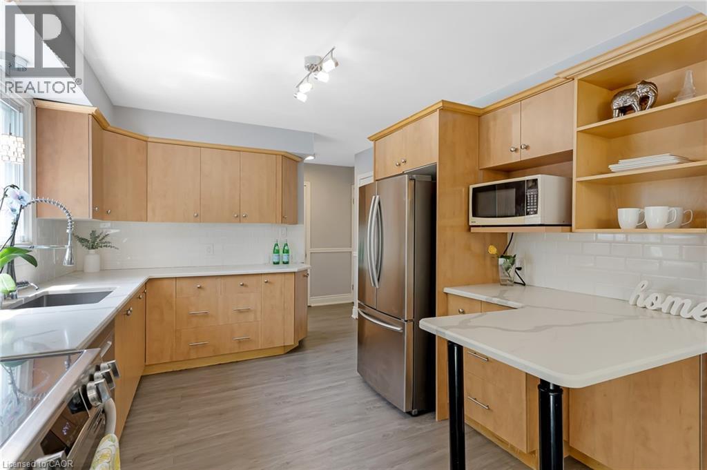 Kitchen featuring light wood cabinetry, light countertops, and stainless steel appliances - 139 Dorset Road, Cambridge, ON