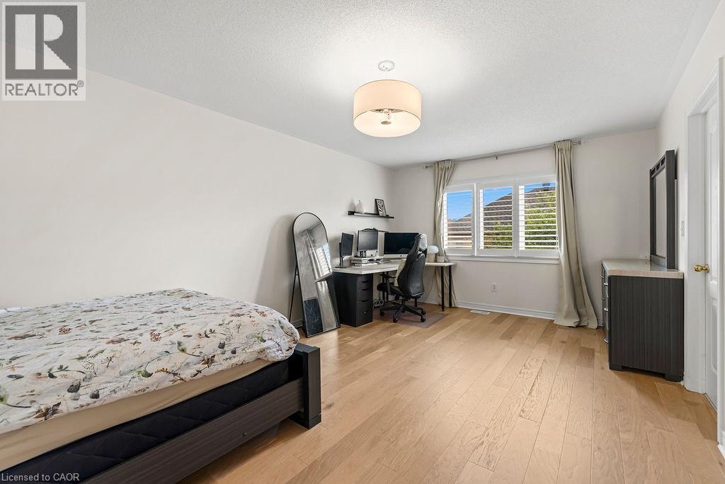 Bright room featuring wood-finish flooring and a white ceiling - 4670 Thomas Alton Boulevard, Burlington, ON