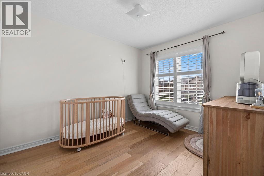 Room featuring wood-finish flooring, white baseboards, and neutral wall tones - 4670 Thomas Alton Boulevard, Burlington, ON