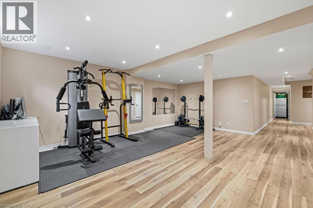 Spacious lower-level room featuring light wood-finish flooring, recessed lighting, and neutral wall tones - 4670 Thomas Alton Boulevard, Burlington, ON