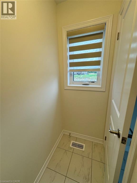 Well-lit closet featuring wood-finish flooring and extensive shelving with hanging rods - 10 Guernsey Drive Unit# Upper, Kitchener, ON