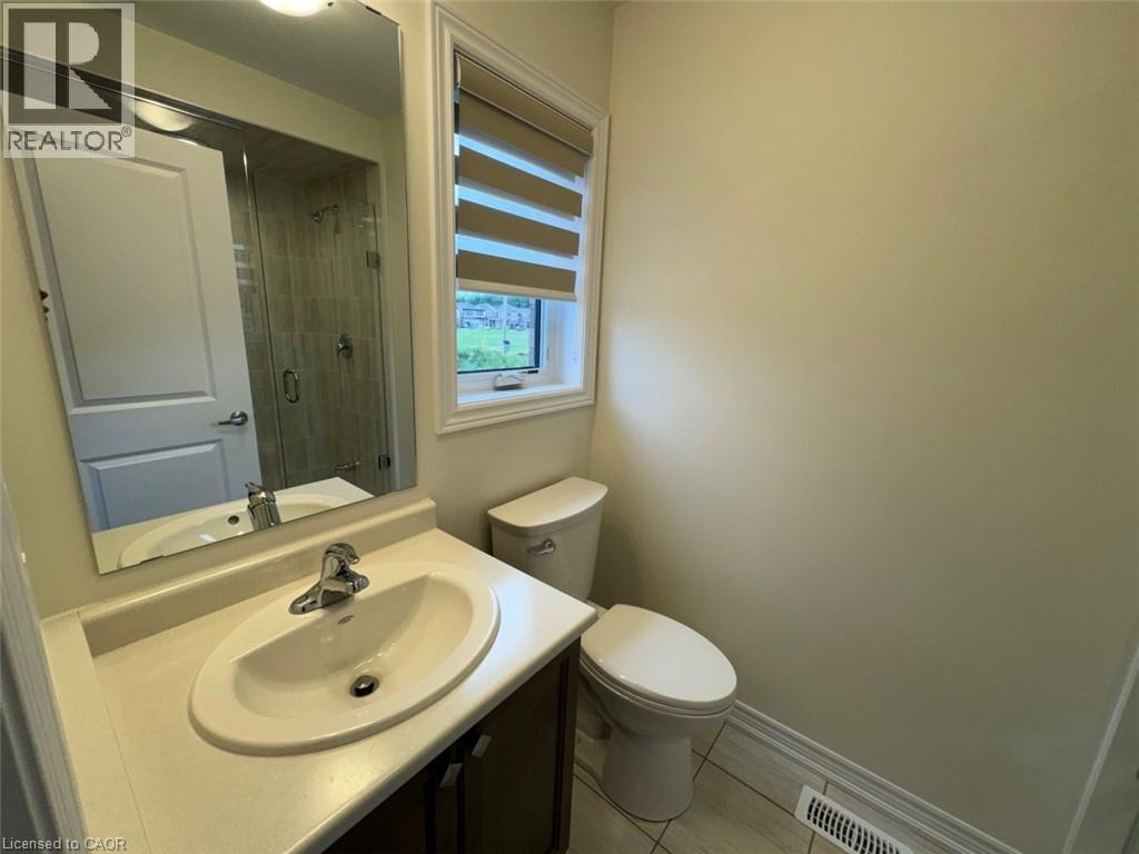 Bathroom vanity with an integrated sink, polished chrome faucet, and a large mirror - 10 Guernsey Drive Unit# Upper, Kitchener, ON