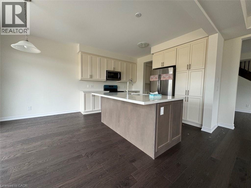 Modern kitchen featuring a central island with a light-toned base and a light-colored countertop - 10 Guernsey Drive Unit# Upper, Kitchener, ON