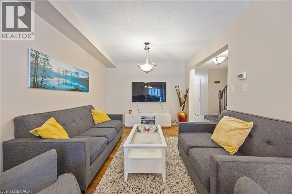 Recessed ceiling lighting, wood-finish flooring, and a contemporary ceiling fixture - 125 Terni Boulevard, Hamilton, ON - Indoor Photo Showing Living Room