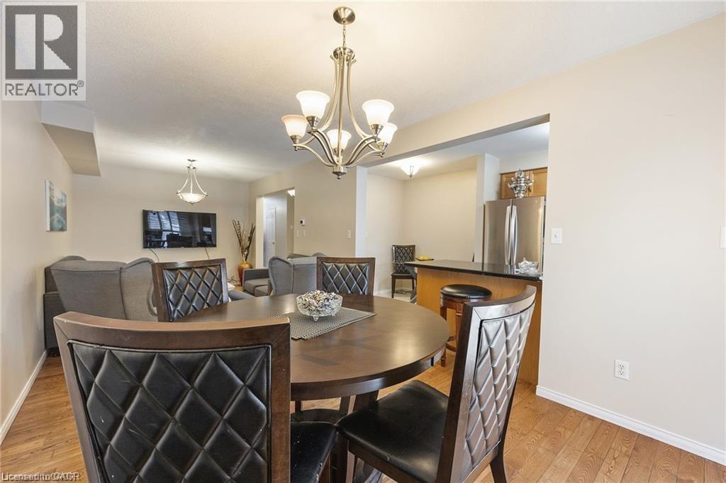 Open-concept living space featuring wood-finish flooring, a contemporary chandelier, and recessed lighting - 125 Terni Boulevard, Hamilton, ON