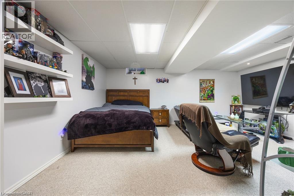 Carpeted room featuring white walls and a drop ceiling with recessed lighting - 125 Terni Boulevard, Hamilton, ON