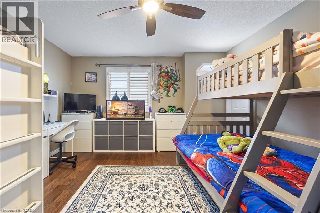 Wood-finish flooring, ceiling fan, window with horizontal blinds, built-in shelving, and bunk bed - 125 Terni Boulevard, Hamilton, ON - Indoor Photo Showing Office