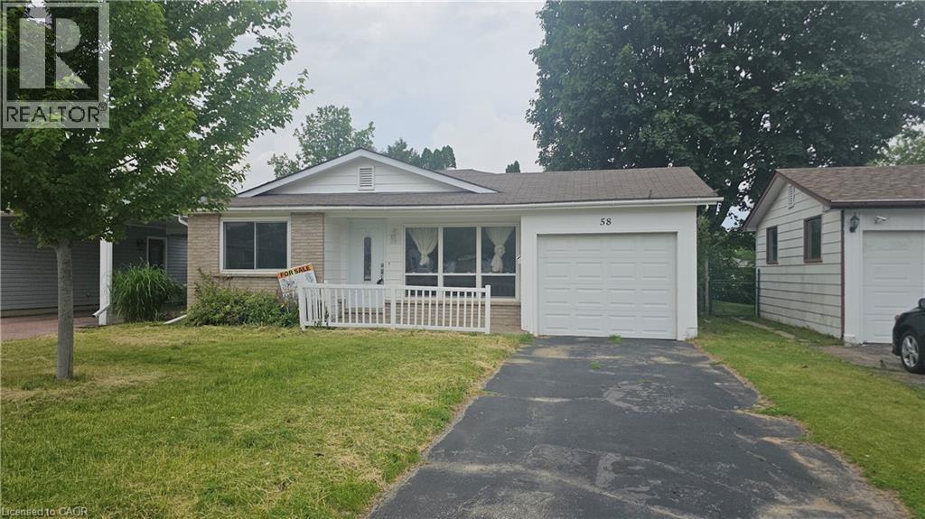 Ranch-style exterior with brick and siding facade, covered front porch, white picket fence, and attached single-car garage - 58 Belwood Crescent, Kitchener, ON