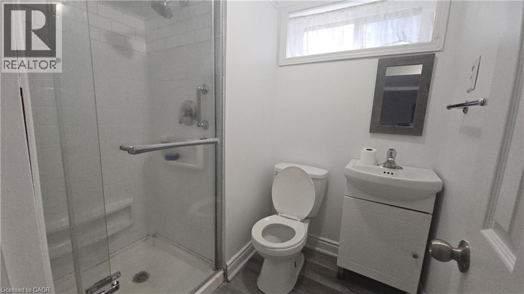 Bathroom featuring a glass-enclosed shower, white subway tile surround, and a wall-mounted showerhead - 58 Belwood Crescent, Kitchener, ON