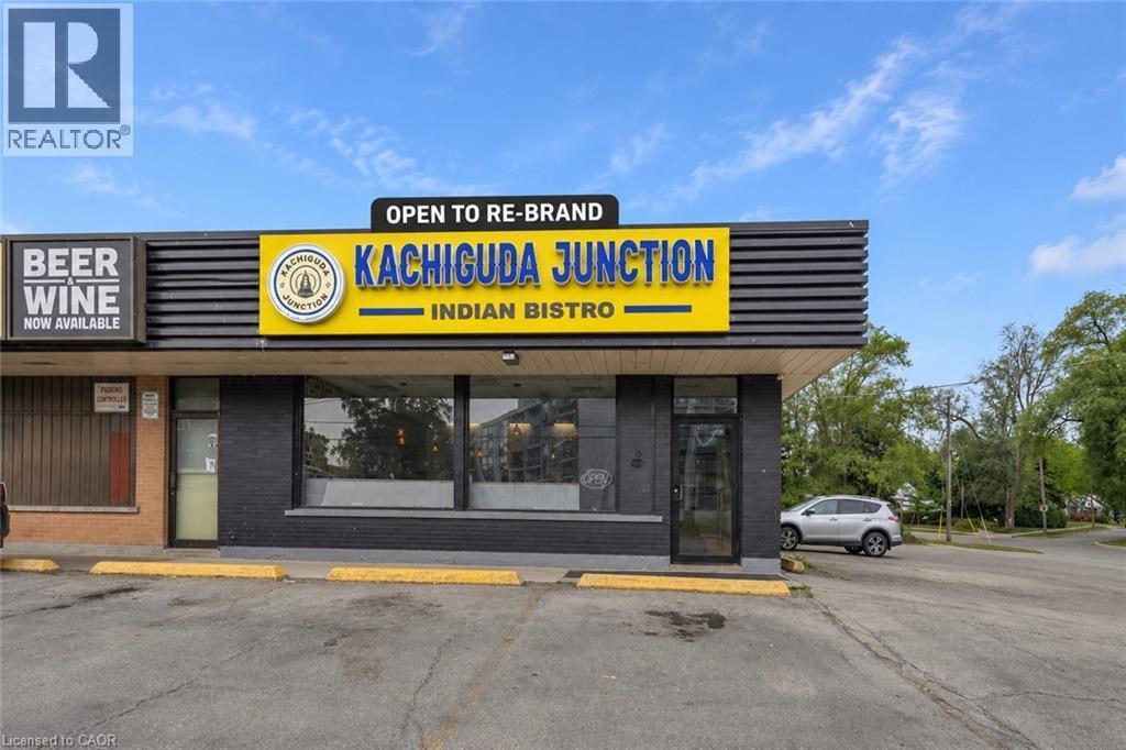 Commercial storefront with ample parking, prominent signage, expansive front windows, and a dedicated entrance - 155 Highland Road E, Kitchener, ON