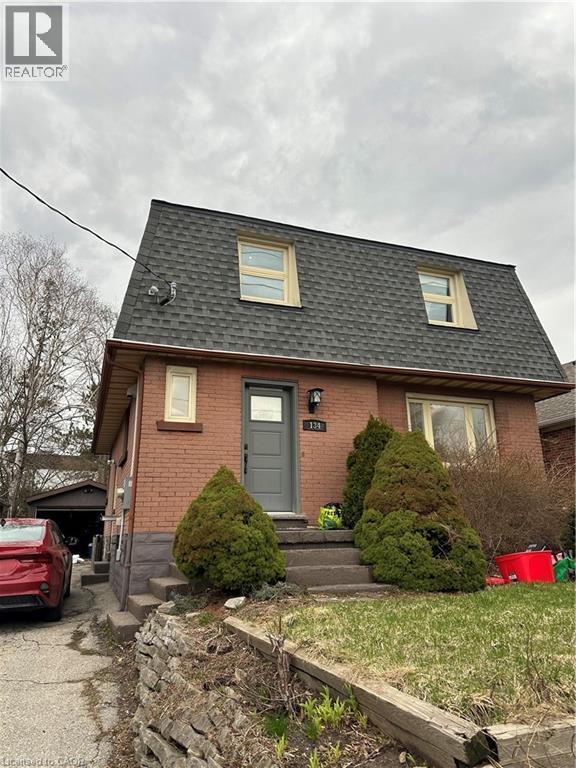 Brick exterior residence featuring a grey shingle gambrel roof with two dormer windows - 134 Bridgeport Road E Unit# Upper, Waterloo, ON