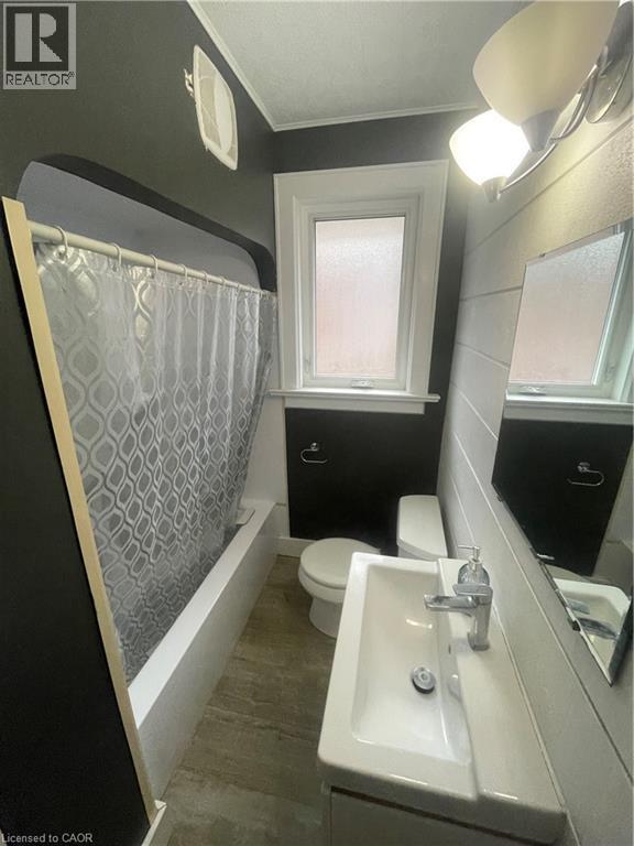 Bathroom featuring a white porcelain vanity with integrated sink, chrome faucet, and a wall-mounted mirror - 134 Bridgeport Road E Unit# Upper, Waterloo, ON