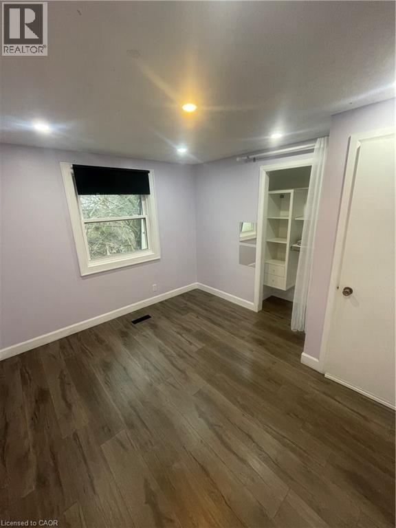 Room featuring wood-finish flooring, recessed lighting, and a window with a black roller shade - 134 Bridgeport Road E Unit# Upper, Waterloo, ON