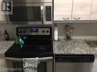 Kitchen featuring stainless steel appliances, speckled stone countertops, and light wood-finish cabinetry - 280 Lester Street Unit# 607, Waterloo, ON