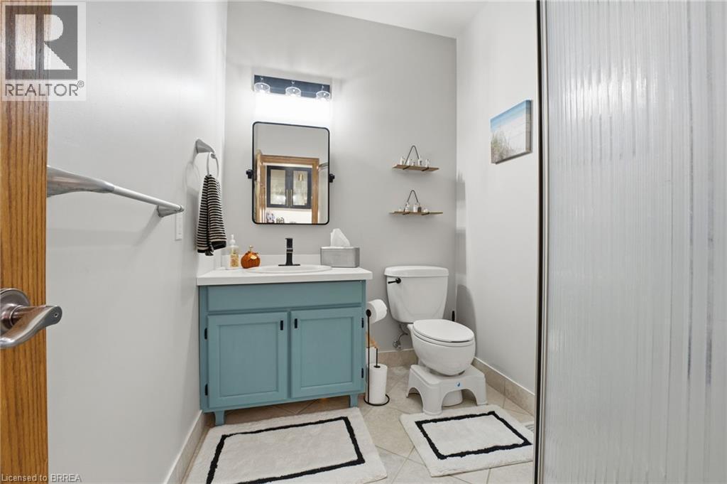 Bathroom featuring a blue painted vanity with a white countertop and a black-framed mirror - 271 Windham Rd 14, Simcoe, ON