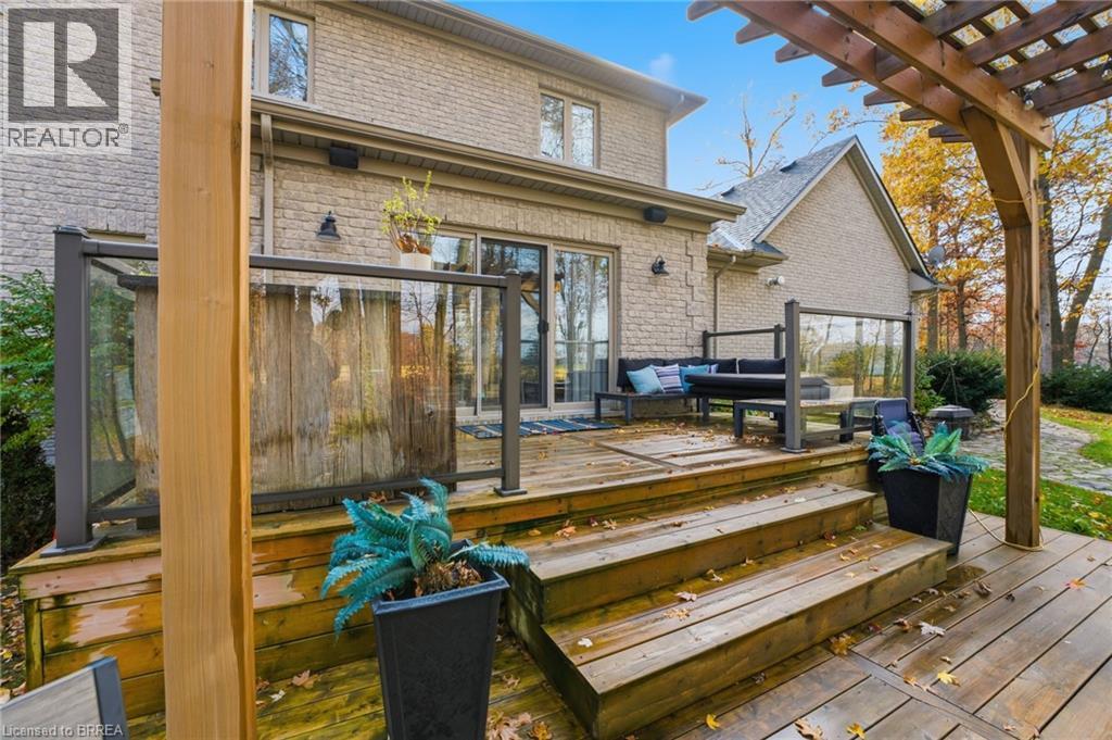 Multi-level wooden deck featuring glass panel railings - 271 Windham Rd 14, Simcoe, ON