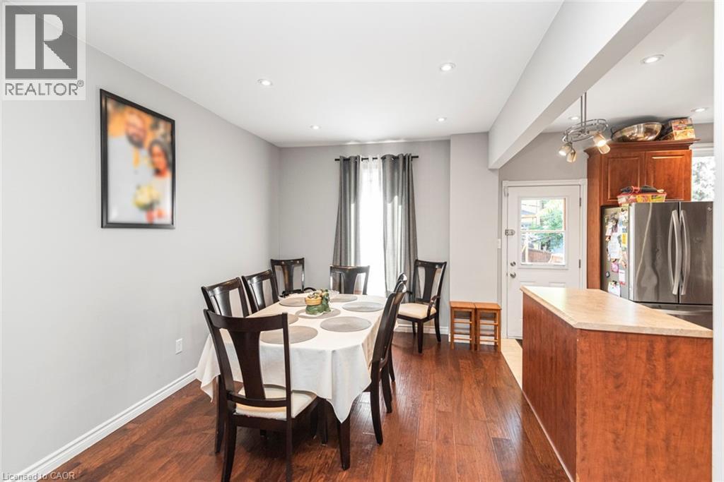 Open-concept dining area featuring recessed lighting, wood-finish flooring, and a window with dark drapery - 38 Fairleigh Avenue N, Hamilton, ON