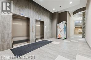 Twin stainless steel elevators set within a textured wall - 280 Lester Street Unit# 607, Waterloo, ON
