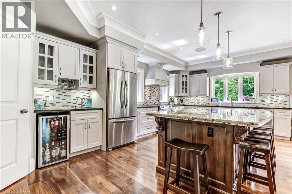 This kitchen is perfect for both entertaining and everyday, features a bar area with sink and fridge, walk in pantry, large island and more. - 59 Decou Road, Simcoe, ON