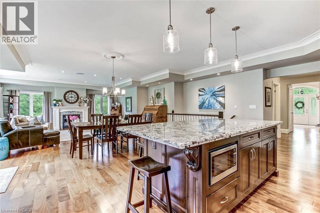 The large Island with seating is open to the dining area and living room and just steps away from the back deck. - 59 Decou Road, Simcoe, ON