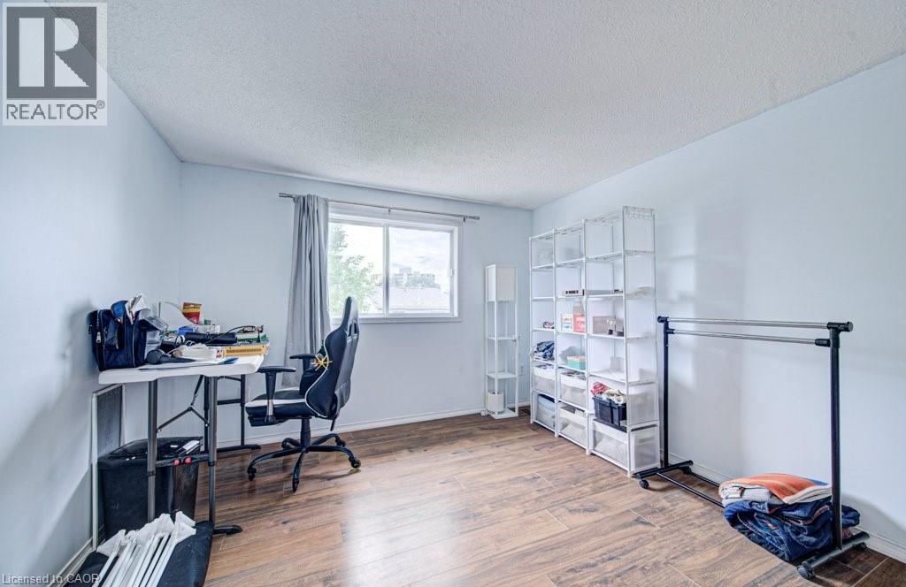 Room featuring wood-finish flooring, light blue walls, and a white ceiling - 854 Elgin Street N, Cambridge, ON