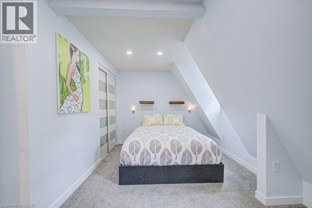 Bedroom featuring a neutral color palette, recessed ceiling lighting, and soft gray carpeting - 854 Elgin Street N, Cambridge, ON