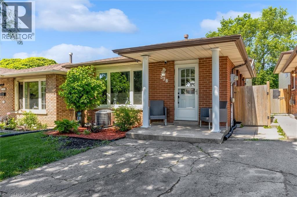 Brick exterior featuring a covered front porch with white columns - 338 East 24Th Street, Hamilton, ON