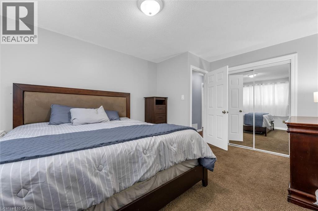 Bedroom featuring light gray walls, brown carpet flooring, and a flush mount ceiling light - 338 East 24Th Street, Hamilton, ON