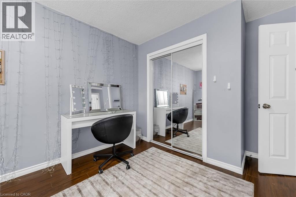 Interior room featuring dark wood-finish flooring, light grey walls, and white baseboards - 338 East 24Th Street, Hamilton, ON