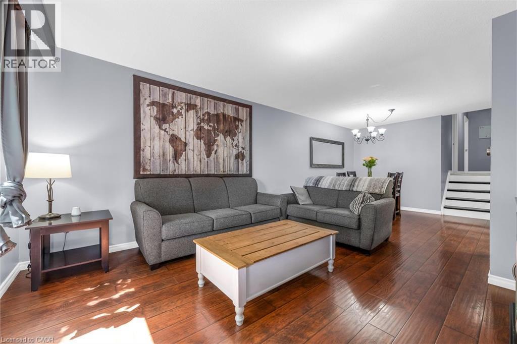 Open-concept living space featuring wood-finish flooring, light grey wall paint, and white trim - 338 East 24Th Street, Hamilton, ON