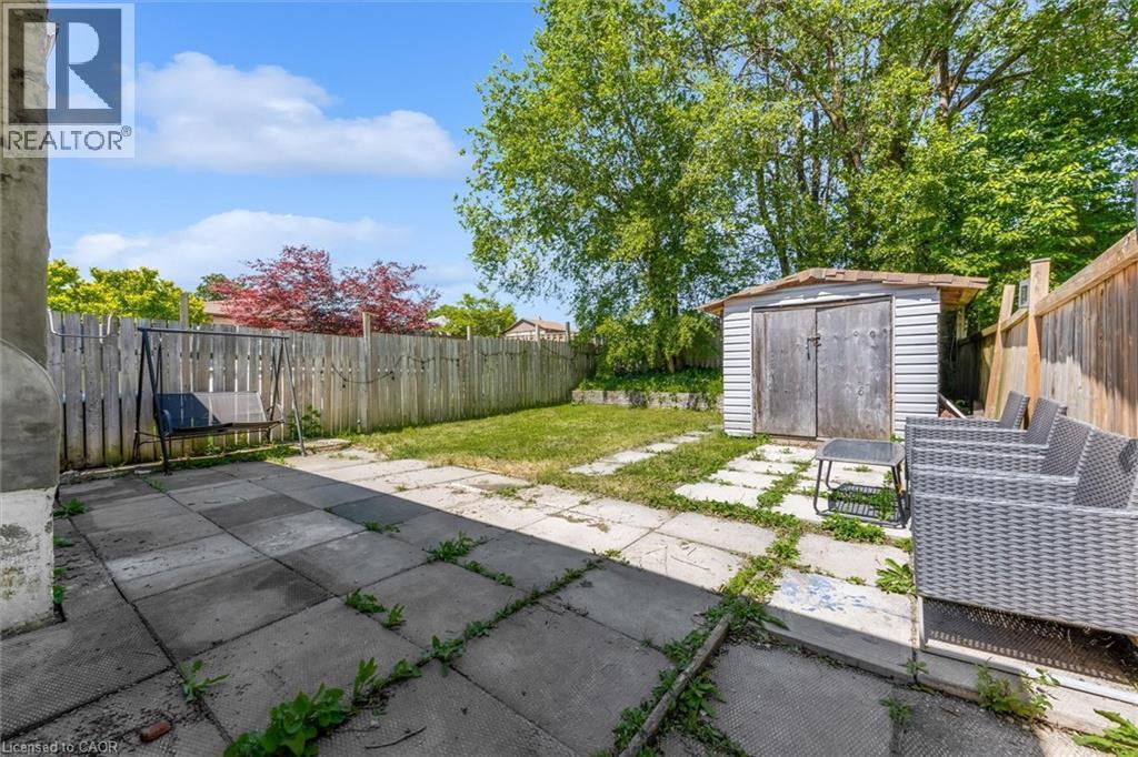 Expansive backyard featuring a combination of concrete patio and natural grass areas - 338 East 24Th Street, Hamilton, ON