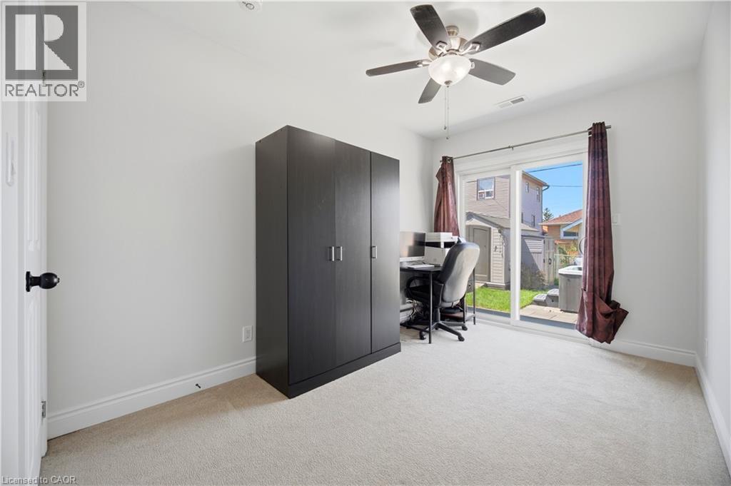 Room featuring light-colored carpeting, white walls, and a ceiling fan with integrated lighting - 71 Beland Avenue N, Hamilton, ON - Indoor