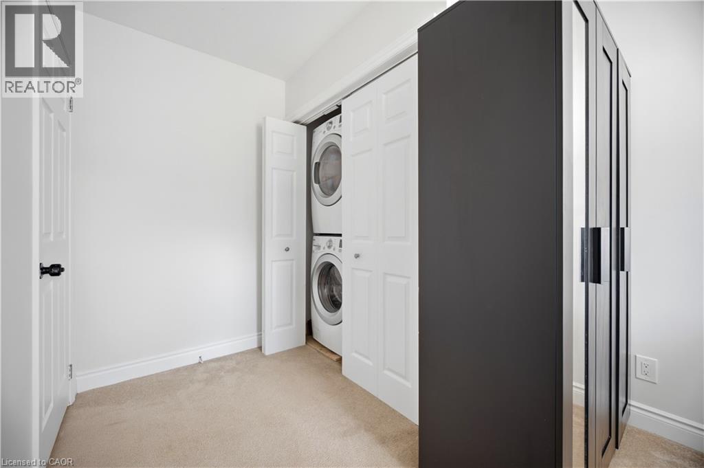 Dedicated laundry closet featuring a stacked washer and dryer - 71 Beland Avenue N, Hamilton, ON - Indoor Photo Showing Laundry Room