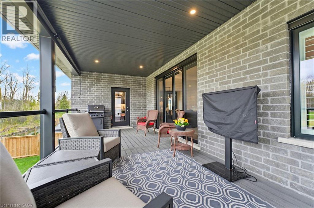 Covered outdoor patio featuring a composite deck, recessed lighting, and a brick exterior - 37 Gilmer Crescent, Listowel, ON - Outdoor With Deck Patio Veranda With Exterior