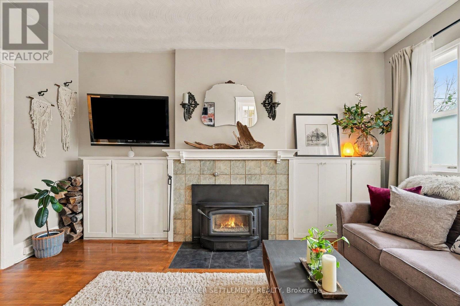 Cozy up by the wood burning fireplace. - 1 Burchell Boulevard, Perth, ON - Indoor Photo Showing Living Room With Fireplace