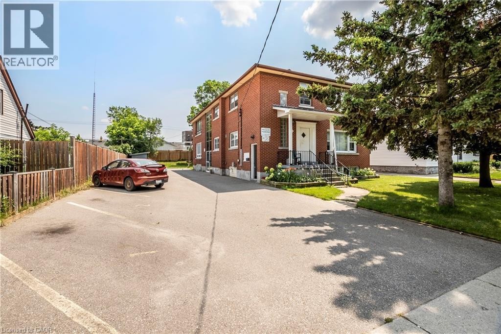 Brick exterior structure with white trim windows and a covered entrance featuring decorative pillars - 43 Sixth Avenue, Kitchener, ON - Outdoor