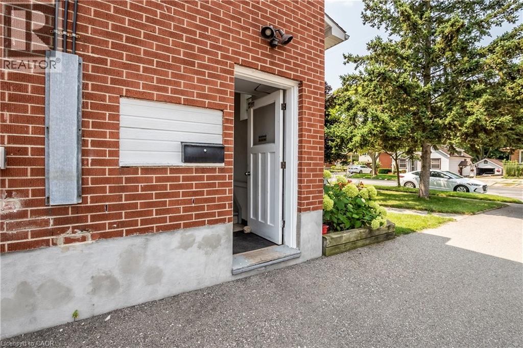 Brick exterior with a white entry door, recessed wall panel, and planter box - 43 Sixth Avenue, Kitchener, ON - Outdoor