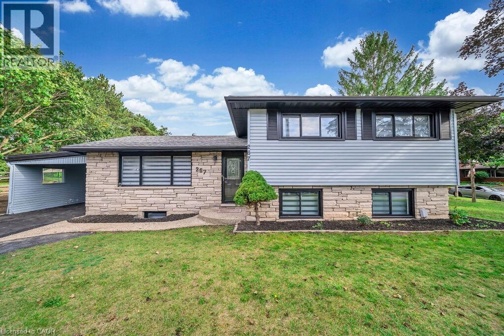 Tri-level home featuring a front lawn, a carport, stone siding, and asphalt driveway - 267 Erb Street E, Waterloo, ON - Outdoor