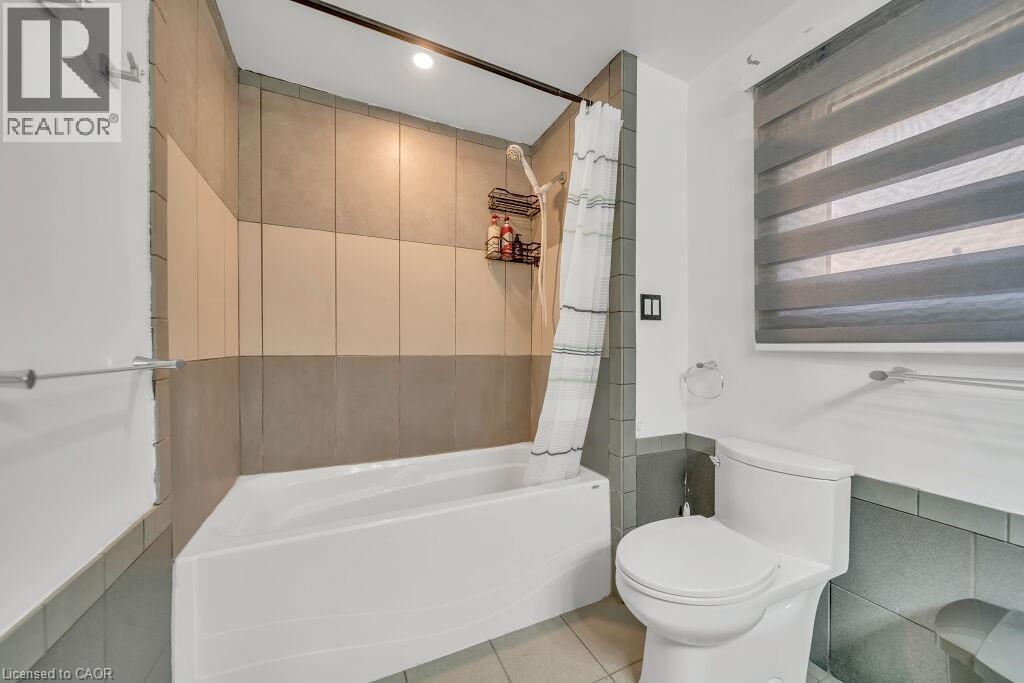 Full bathroom Upstairs with tile walls, shower / tub combo, and light tile patterned floors - 267 Erb Street E, Waterloo, ON - Indoor Photo Showing Bathroom