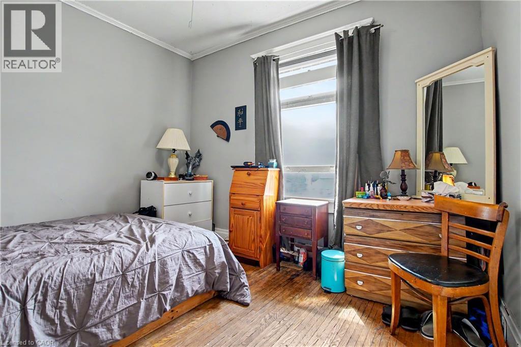 2nd Floor Bedroom Hardwood flooring, crown molding, and a window with roller shades and drapery - 30 Hohner Avenue, Kitchener, ON - Indoor Photo Showing Bedroom