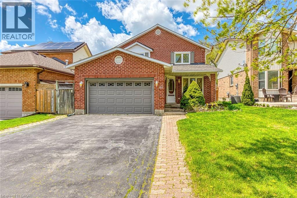 Brick-clad two-story residence featuring an attached garage with a grey panel door - 43 Niska Drive, Waterdown, ON - Outdoor